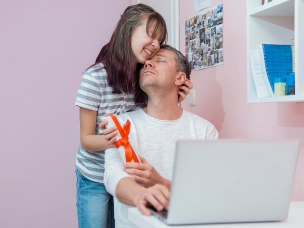 Foto gratuita figlia che fa un regalo a suo padre