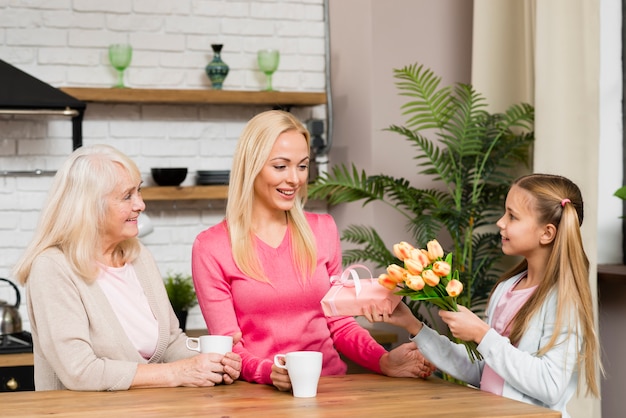 Daughter giving mother a bouquet of flowers