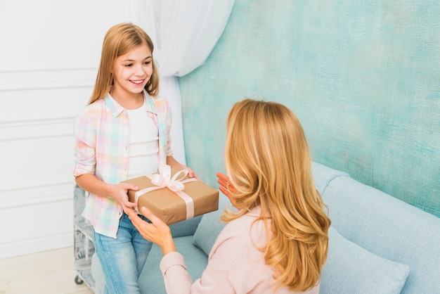 Daughter giving present box for mother