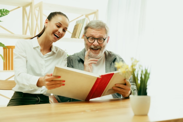 A daughter or granddaughter spends time with the grandfather or senior man