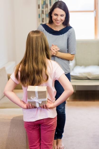 Daughter hiding gift box behind her back