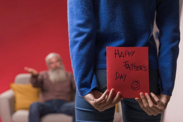 Foto gratuita figlia che tiene una cartolina d'auguri di festa del papà