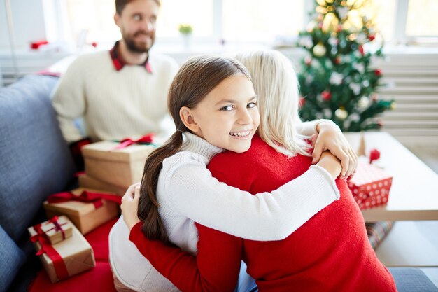 クリスマスの日に母親を抱き締める娘