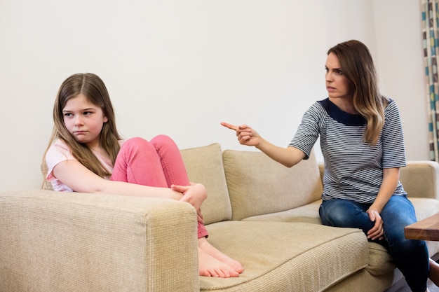 Free photo daughter ignoring her mother after an argument in living room