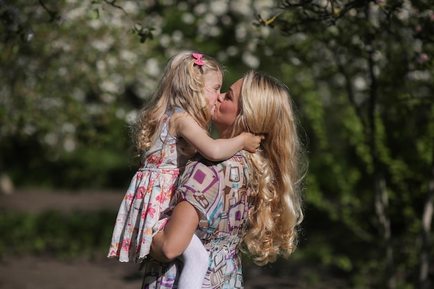 Дочь целует маму в саду