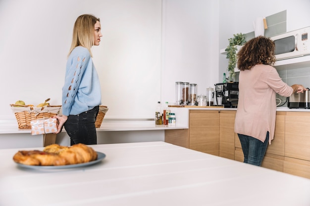 Free photo daughter making surprise for mother in kitchen