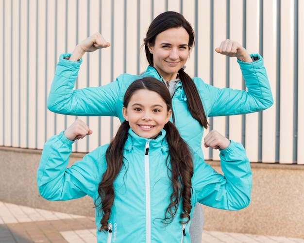 Daughter and mom showing muscles