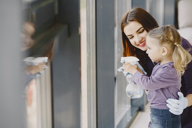 Daughter and mother cleaning window together