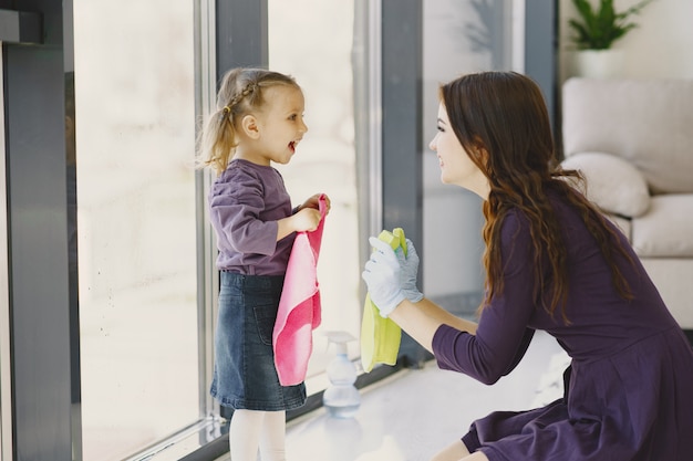 Daughter and mother cleaning window together