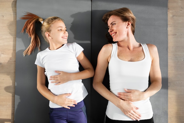 Daughter and mother laying on their backs looking at each other