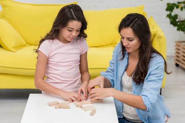 Daughter and mother playing a wooden tower game together