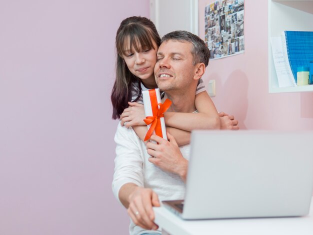 Daughter offers a gift and hugs to his father