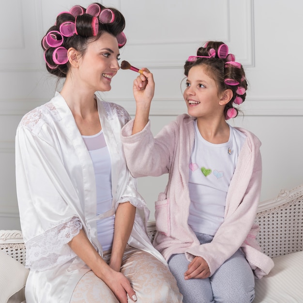 Daughter putting powder on mothers face