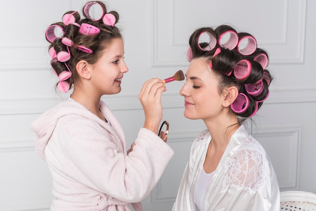 Daughter putting powder on mothers forehead