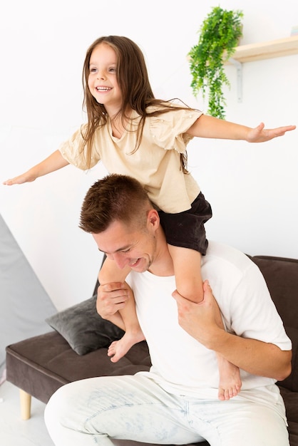 Free photo daughter sitting on her father's shoulders