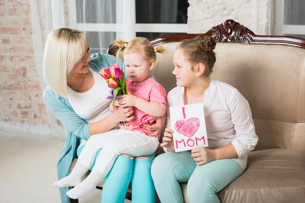 Daughters presenting gifts for mother