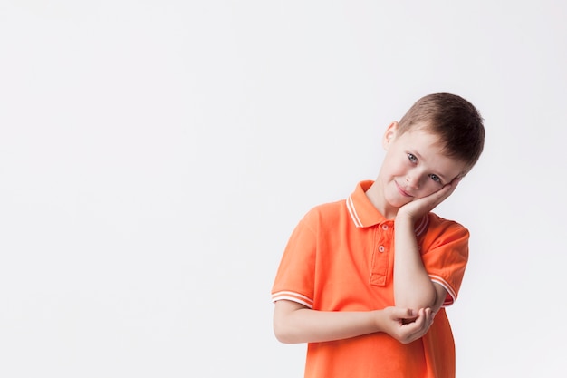 Day dreaming innocent boy looking at camera against white backdrop