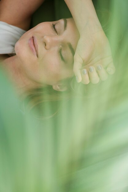 Daydreaming woman and blurred house plant