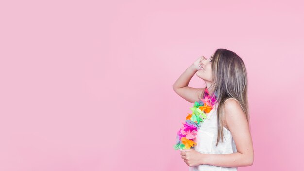 Daydreaming young woman on pink background