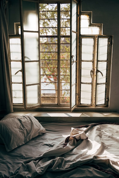 Free photo daylight shining through an unmade bed