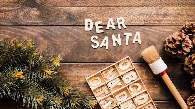 Dear Santa inscription near coniferous twig, snags and letters 