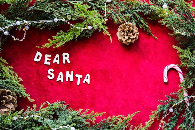 Free photo dear santa title between snags and green coniferous branches