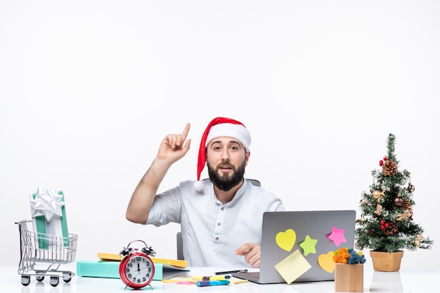 Giovane uomo d'affari deciso in ufficio che celebra il nuovo anno o il natale lavorando da solo