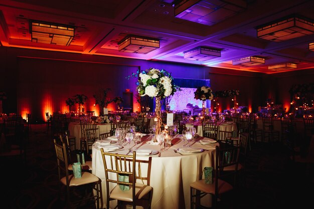 Decorated banquet hall with served round table with hydrangea centerpiece and chiavari chairs