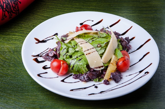 녹색 테이블에 하얀 접시에 시저 샐러드 장식