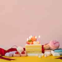 Free photo decorated cakes with candies; marshmallow and macarons on yellow desk