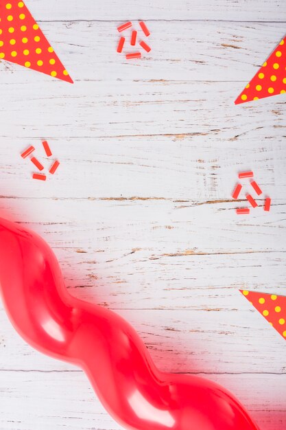 Decorated candies, polka dot paper and balloon on wooden table