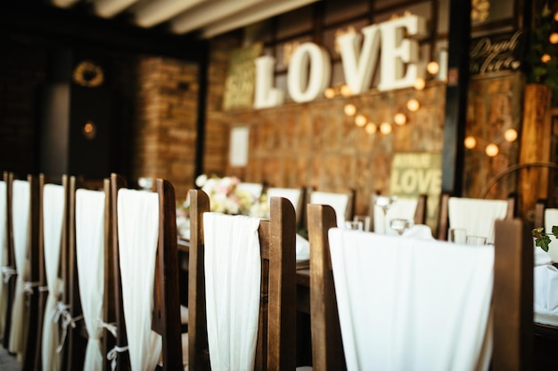 Decorated chairs at indoor wedding reception.