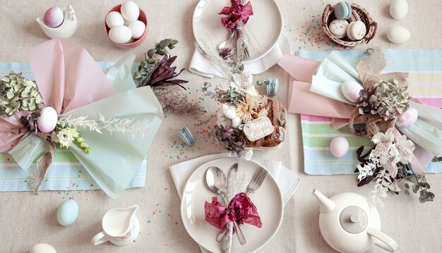 イースターのデザート、お茶、卵を平らに置いた装飾されたお祝いのテーブル。ハッピーイースターのコンセプト。