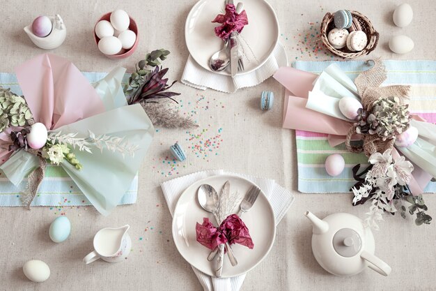 Decorated festive table with Easter dessert, tea and eggs flat lay. Happy Easter concept.