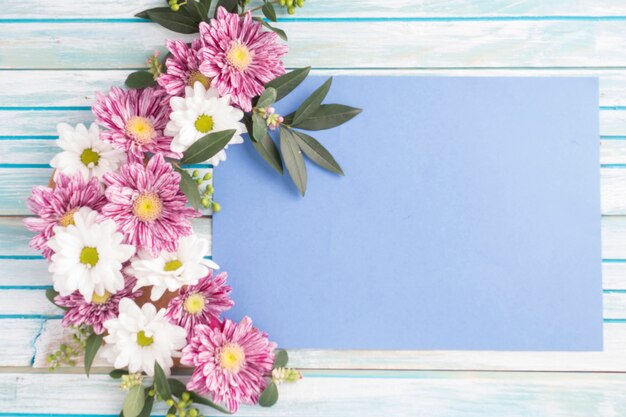 Decorated flowers design on blank paper over the wooden table