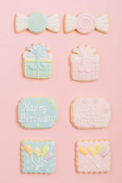 Decorated gingerbread birthday cookies arranged on pink background