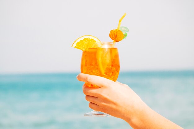 Decorated glass of amazing orange drink  in hand