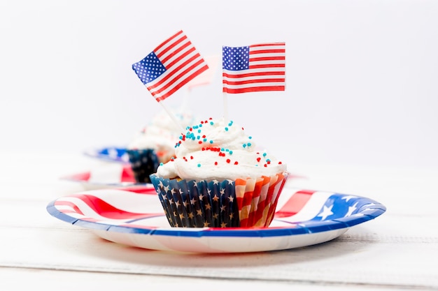 Decorated with small USA flags and topping cake on plate
