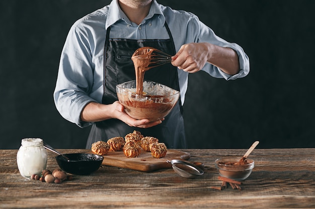 Decorating delicious homemade eclairs with chocolate and peanuts