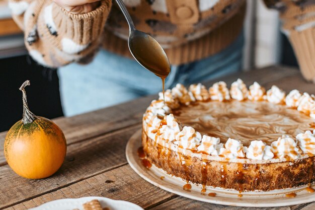 Foto gratuita processo di decorazione di pumpkin cheesecake - dessert del ringraziamento