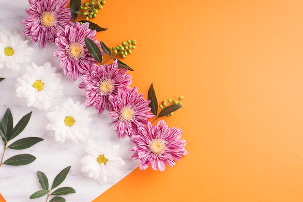 Decoration of flowers on white paper over the orange background