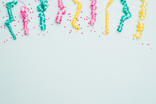 Decoration of streamers and confetti on blue background