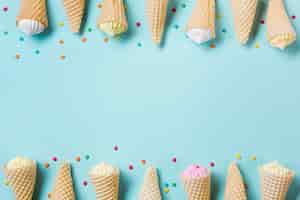 Free photo decoration of waffle cone with aalaw and sprinkles on blue backdrop