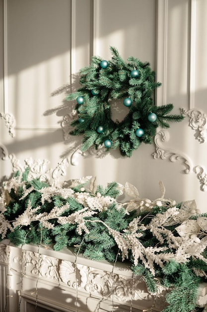 Украшения на новый год, венок из еловых веток на стене. рождественский декоративный венок в уютном доме Premium Фотографии