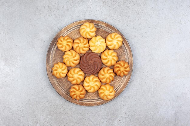 A decorative arrangement of cookies on wooden board on marble background. High quality photo