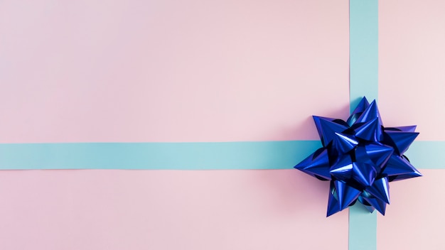 Decorative blue ribbon and bow on pink background