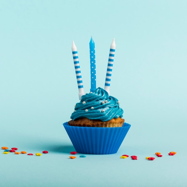 Decorative candles on muffins with star sprinkles against