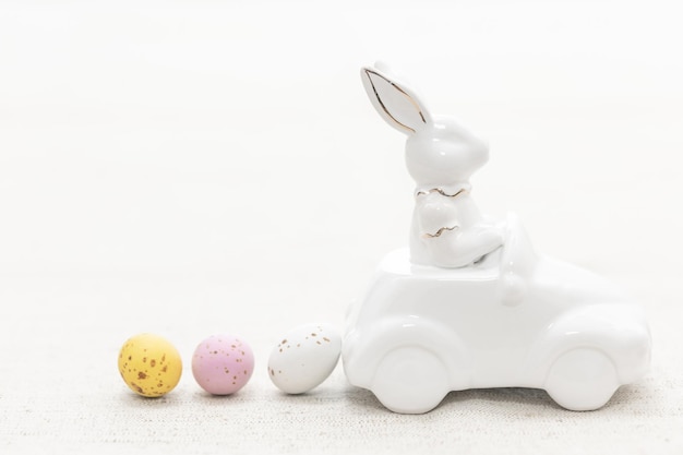 Decorative ceramic hare in a car and Easter eggs closeup