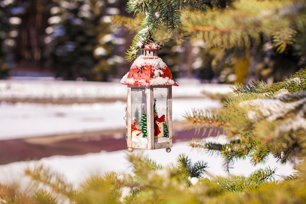 雪​の​冬​の​日​の​モミ​枝​に​装飾的​な​クリスマス​ランタン