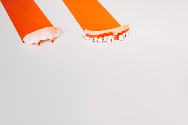 Decorative deformed human teeth on orange paper